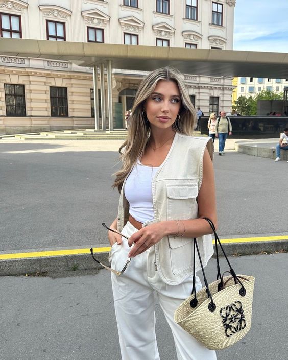 White crop top and trousers paired with a LOEWE straw bag